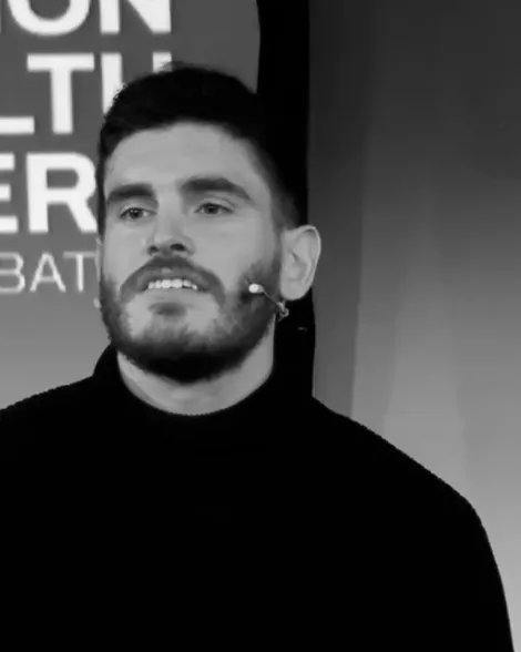 Retrato en blanco y negro de David Garrido Leal, con micrófono de diadema, durante una ponencia.