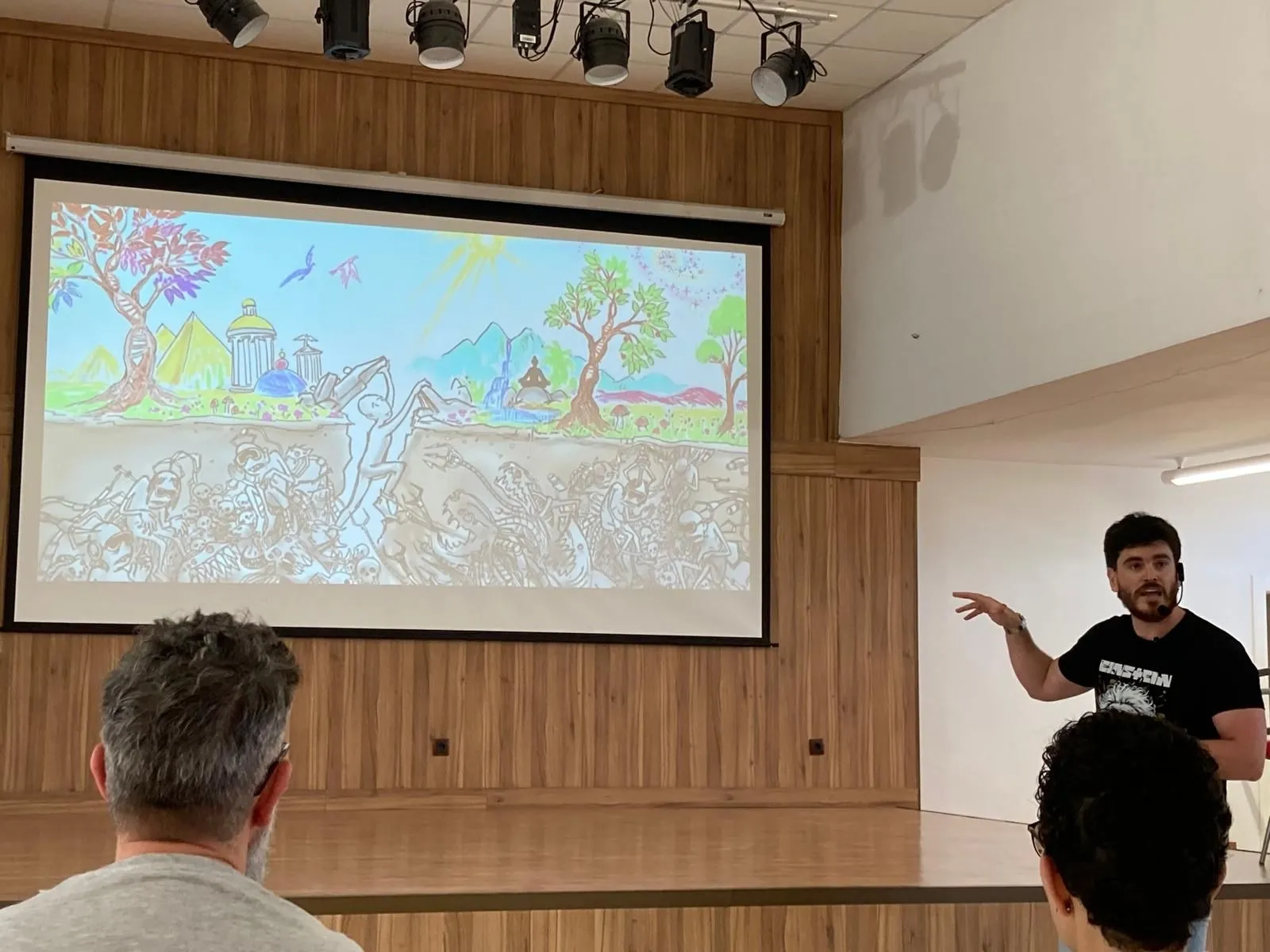 David Garrido Leal impartiendo una formación ante un grupo, con una ilustración proyectada.